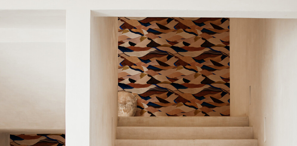 Non-woven wallpaper with a graphic pattern of desert dunes in terracotta and orange tones